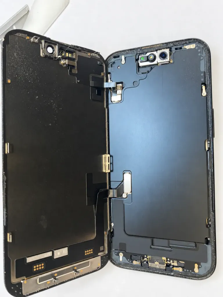 iPhone 15 opened with the old screen supported beside the device
