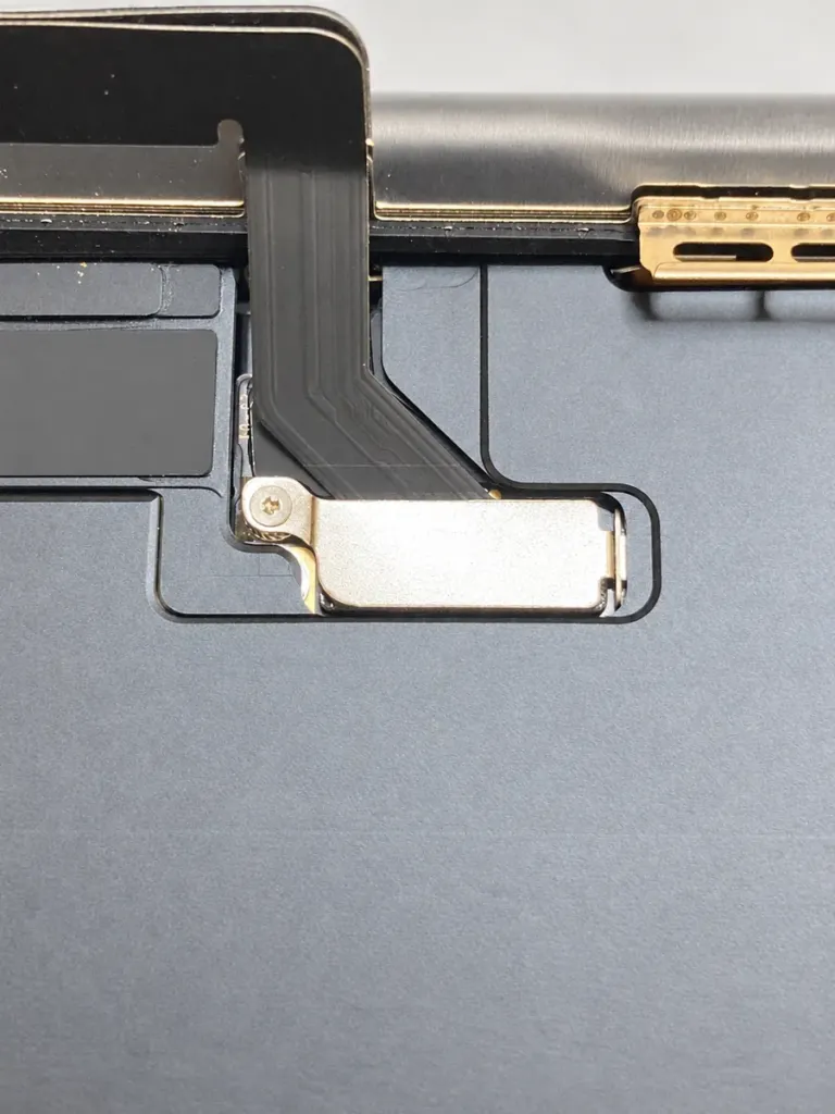 Close-up of the iPhone 15 display connector protective cover and retaining screw